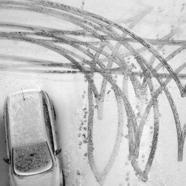 aerial view of snow covered parking lot and car