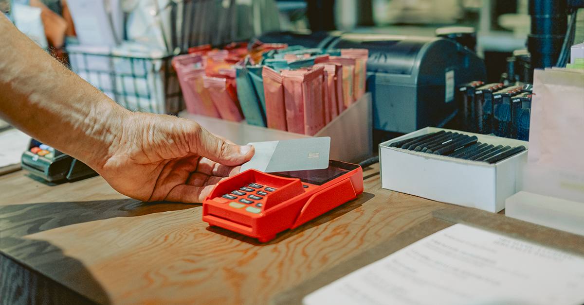 A person using their credit card at a cash register.