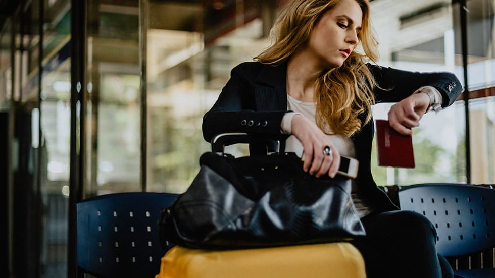 woman at airport checking the time on her watch